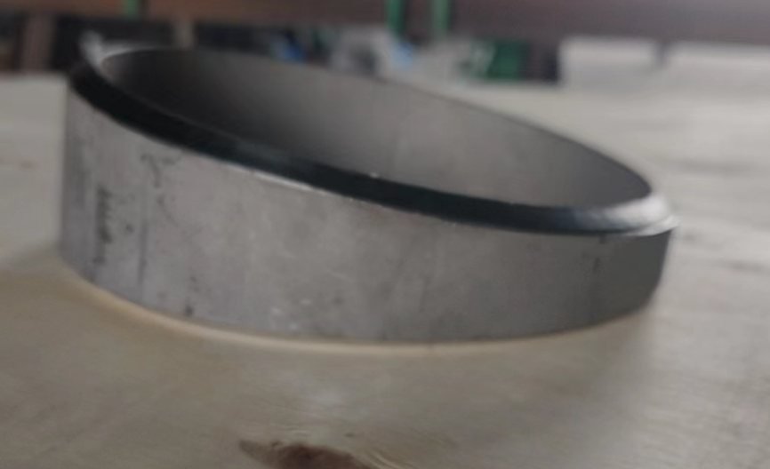 Close view of a smooth angled cut on a stainless steel pipe section